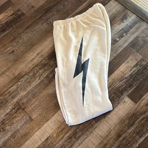 Pale yellow Aviator Nation sweat pants with black bolt on one leg
